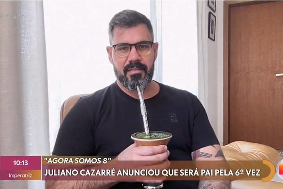 Juliano Cazarré de blusa preta e tomando chimarrão durante entrevista ao Encontro - Metrópoles