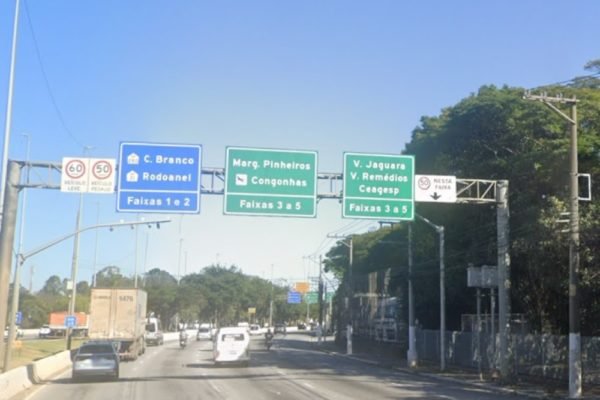 Imagem mostra placas de trânsito, radar e tráfego em avenida - Metrópoles
