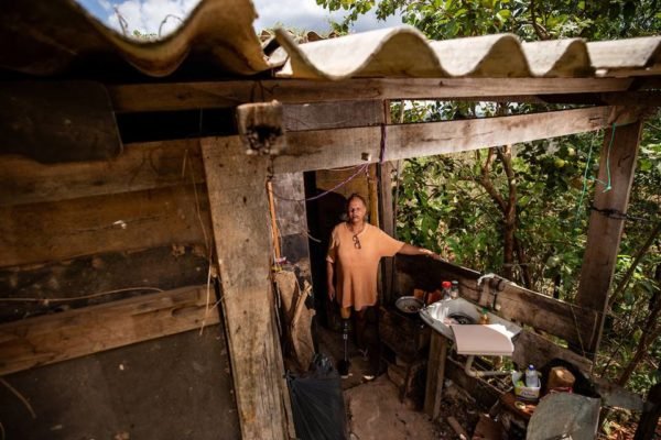 Mulher trans dentro de uma casa de madeira 