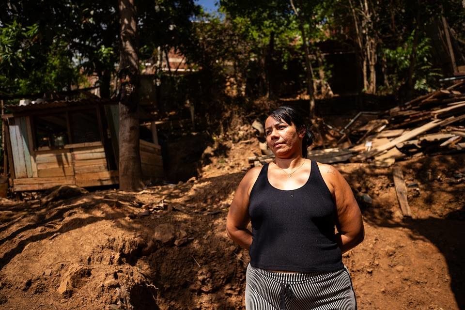 mulher roupa preta em frente a área de risco