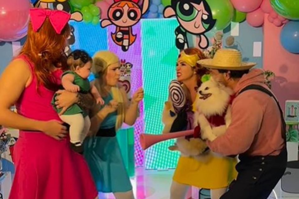 foto colorida de eliezer vestido de florzinha com bebe no colo vestida de docinho ao lado de viih tube vestida de lindinha fingindo uma luta contra mulher vestida de princesa maisgrana e homem festido de fuzzy com cachorro no colo - metrópoles