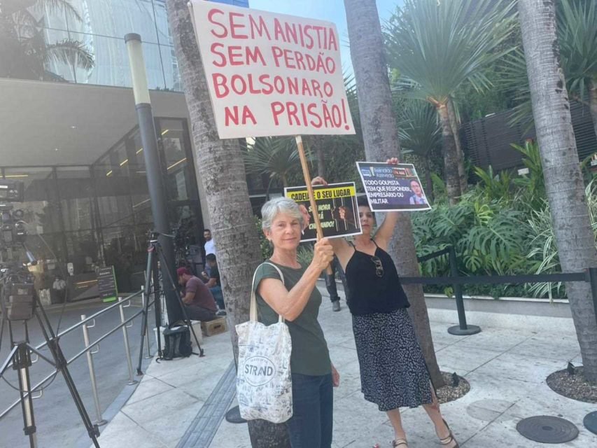 foto colorida mostra mulheres segurando cartazes contra Bolsonaro na porta do Hospital Vila Nova Star - Metropoles