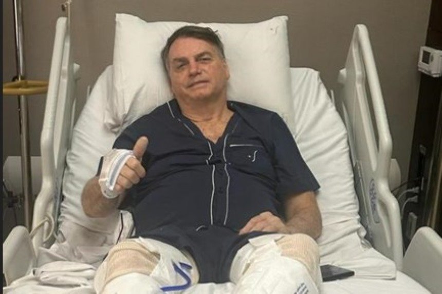 foto colorida mostra Jair Bolsonaro em cama de hospital, fazendo joinha, de pijama - Metropoles