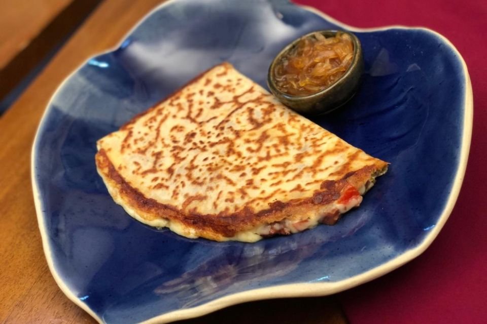 Foto colorida de um crepe no prato azul - Metrópoles