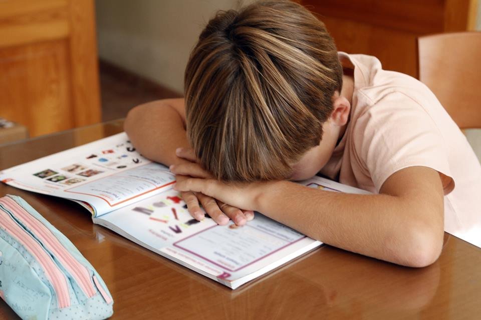  Menino cansado estudando em casa - Metrópoles