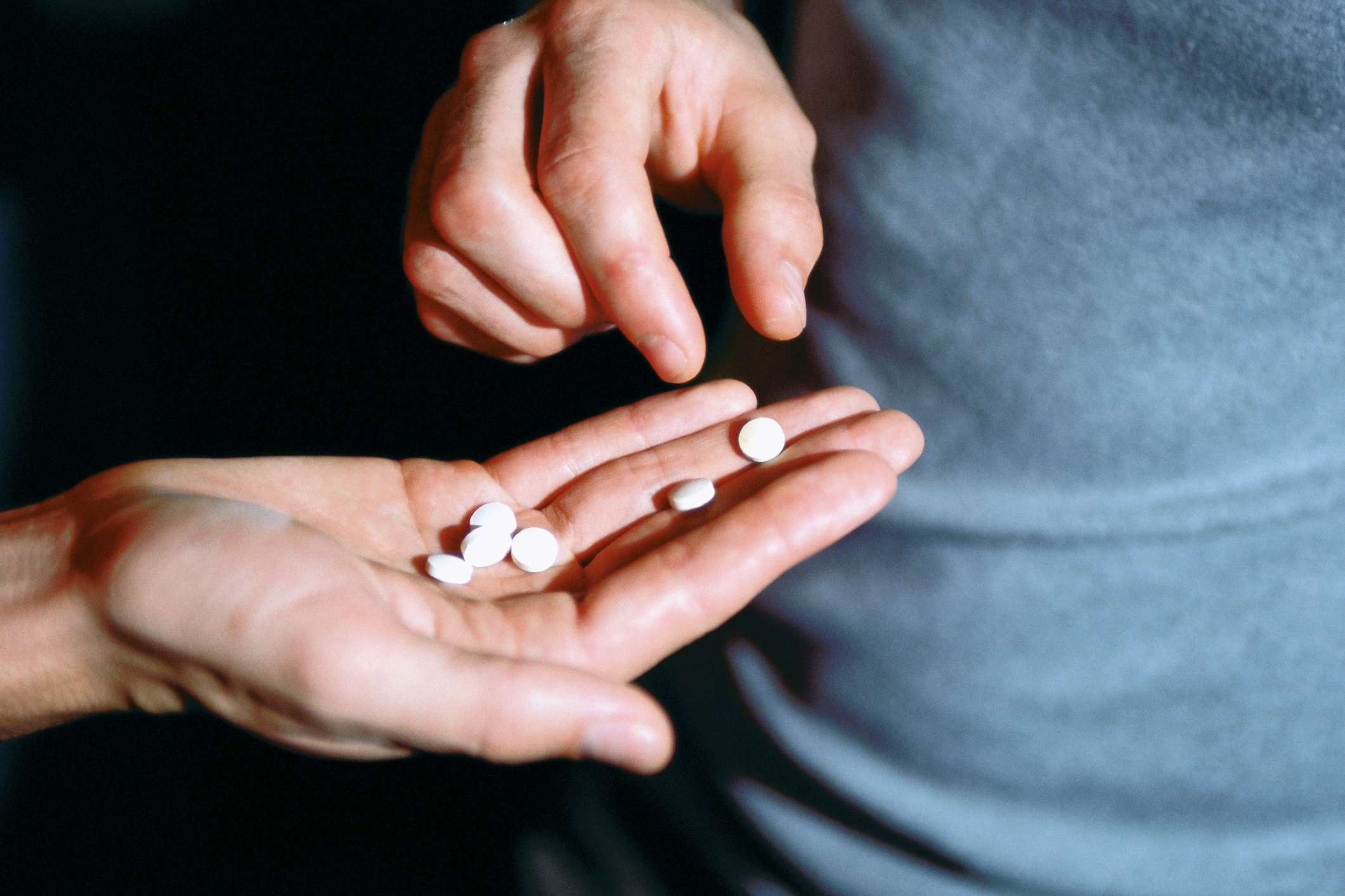 Foto mostra homem oferecendo comprimidos de ecstasy MDMA