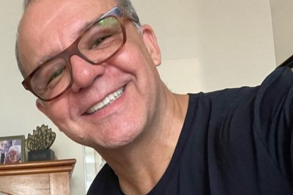 Sérgio Cabral posa sorridente de óculos e blusa preta - Metrópoles