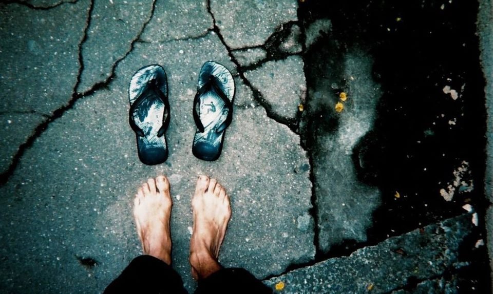 Imagem colorida de pés descalços de pessoa em situação de rua - Metrópoles
