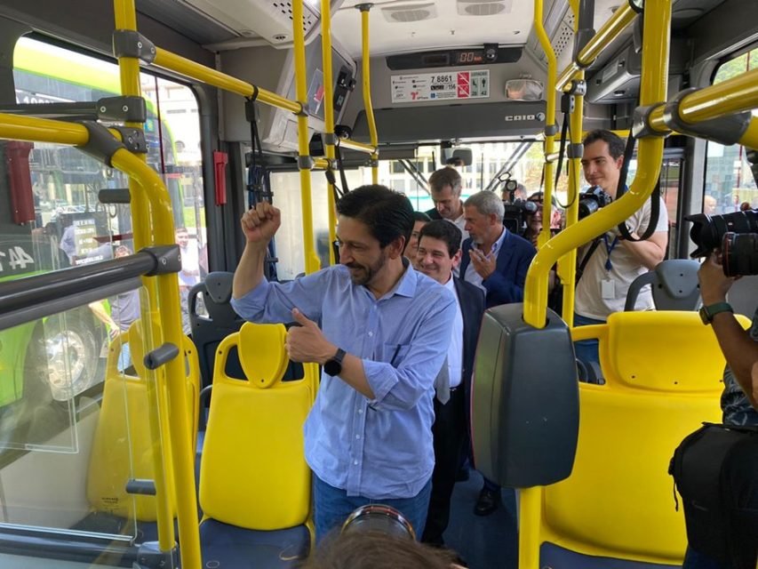 Imagem colorida mostra Ricardo Nunes, homem branco, de camisa azul e calça jeans, dentro de um ônibus. Ele faz sinal de positivo para alguém fora do ônibus - Metrópoles