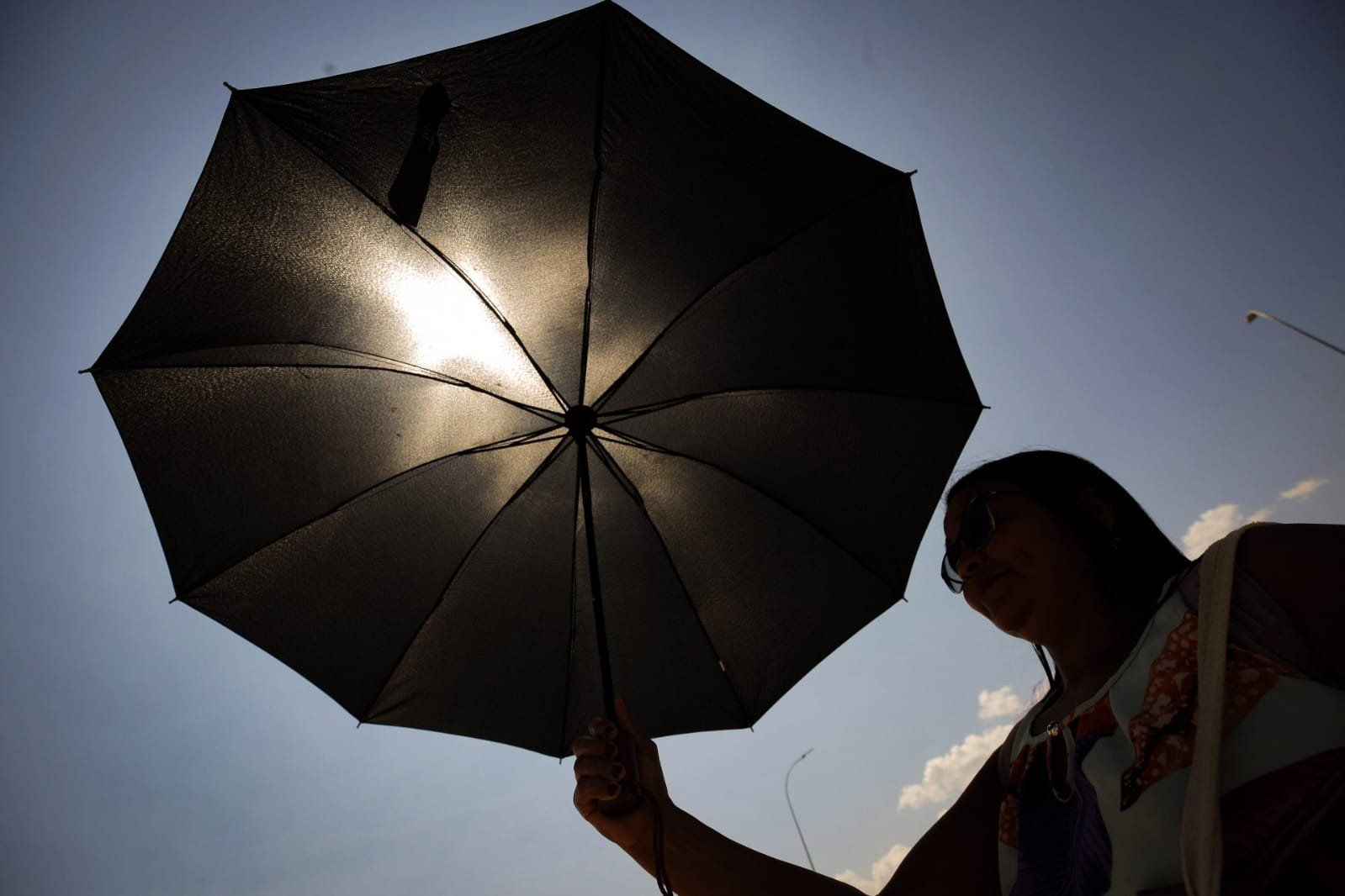 Pessoa se proteje do calor recorde em Brasília Df que chega a 34,6 chuva - Metrópoles