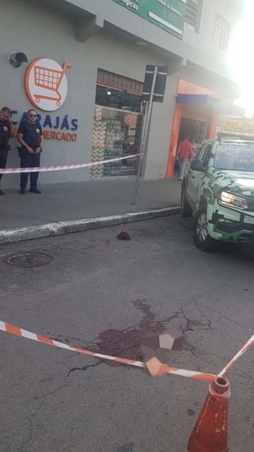 Em foto colorida mancha de sangue no asfalto onde homem foi morto - Metrópoles