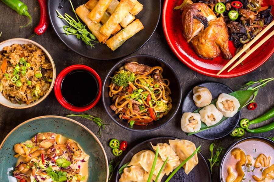 Foto colorida de vários pratos de comida asiática - Metrópoles
