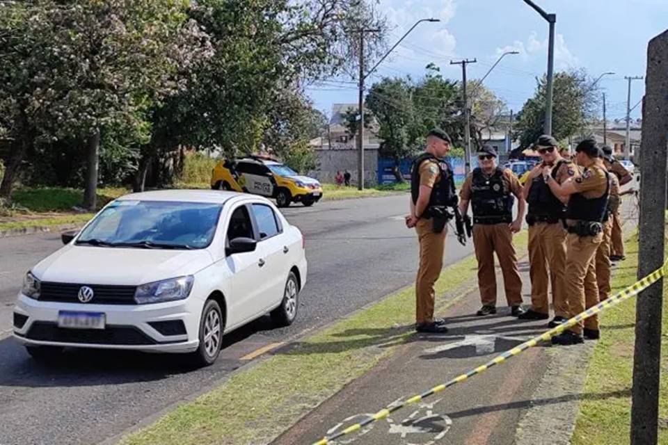 Imagem colorida mostra polícia no local em que um homem foi morto a tiros em um semáforo quando o sinal estava vermelho - Metrópoles