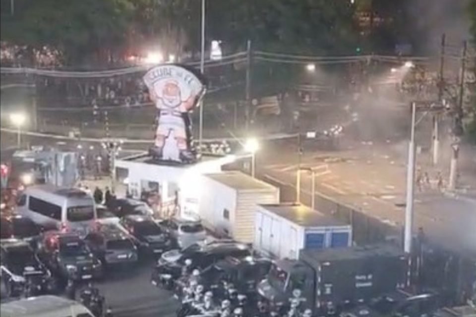 Imagem colorida do local da confusão entre torcedores do São Paulo e a polícia. Há viaturas da PM estacionadas e é possível ver fumaça das bombas - Metrópoles