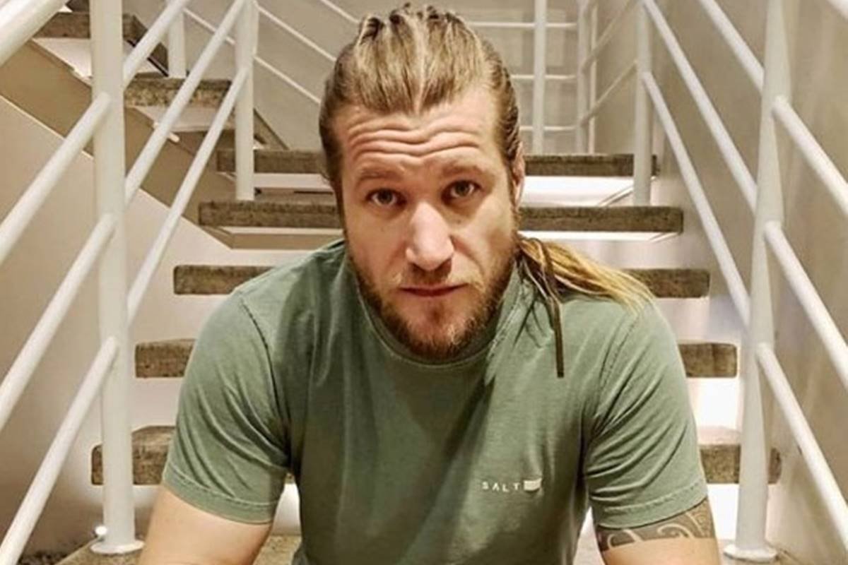 Foto colorida de Diego Alemão sentado em escada - metrópoles