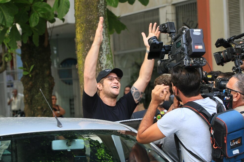 Diego Alemão levanta as mãos para o ar ao ser liberado da delegacia - Metrópoles