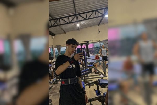 Imagem colorida de jovem tirando foto em espelho de academia - Metrópoles