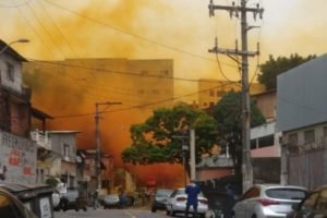 Imagem colorida mostra uma fumaça laranja no meio de uma rua com casas na cidade de Barueri após o vazamento de um produto químico - Metrópoles
