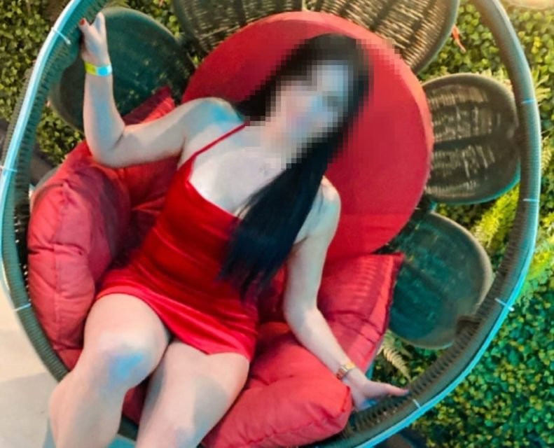 Imagem colorida de mulher com vestido vermelho sentada em poltrona