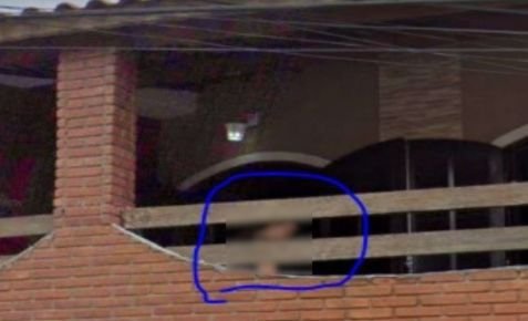 Imagem colorida mostra uma mulher atrás de uma sacada em imagem do Google Street View - Metrópoles