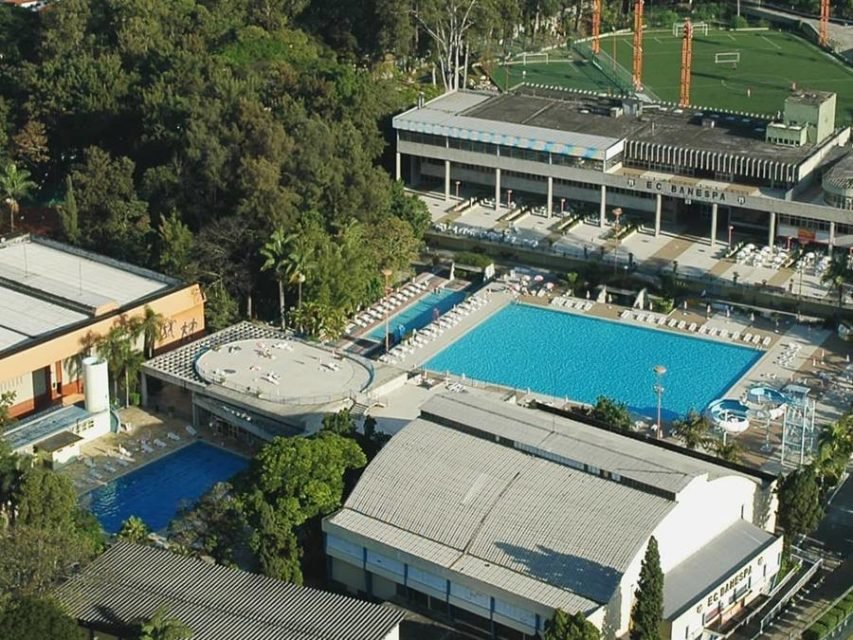 Imagem colorida mostra vista aérea de clube com quadra e piscina - Metrópoles