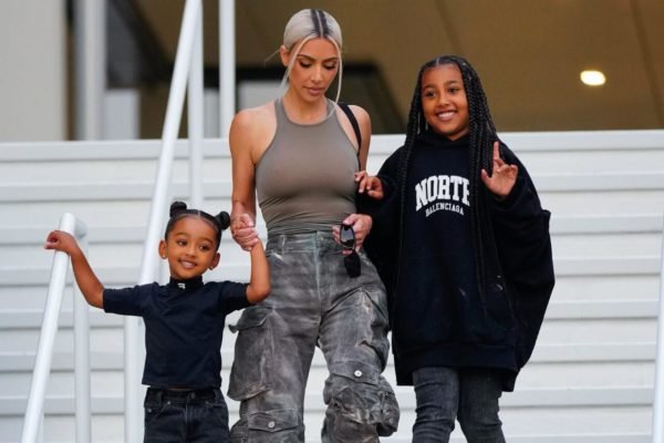 Na imagem com cor, Kim Kardashian com as filhas descendo escadas - Metrópoles