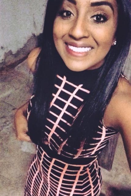 foto colorida. Mulher negra com cabelo preto liso sorrindo