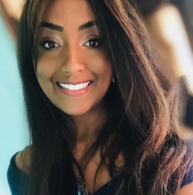 foto colorida. Mulher negra com cabelo preto liso sorrindo