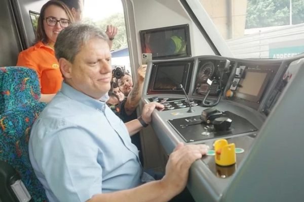 Foto colorida do governador Tarcísio de Freitas sentado de camise dentro de cabine de trem - Metrópoles