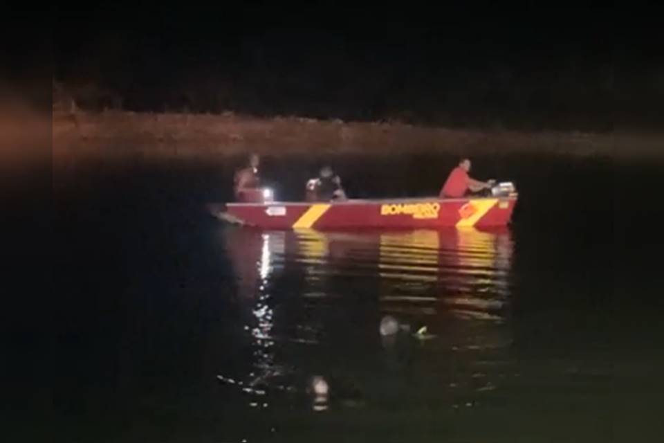barco do corpo de bombeiros na água com dois mergulhadores dentro do rio