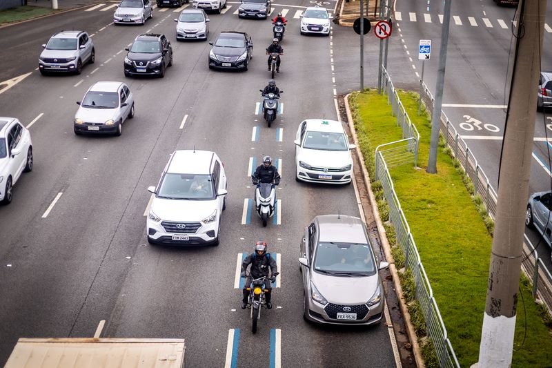 Imagem colorida mostra motos dentro da chamada faixa azul circulando em avenidas com carros nas demais faixas da via em São Paulo - Metrópoles
