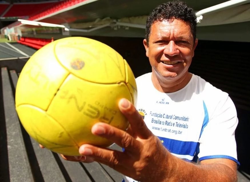 Imagem colorida de homem com camisa branca segurando uma bola de futebol. Briga por herança - Metrópoles
