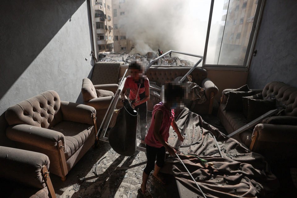 Crianças são vistas em uma casa destruída após ataques israelenses na Cidade de Gaza