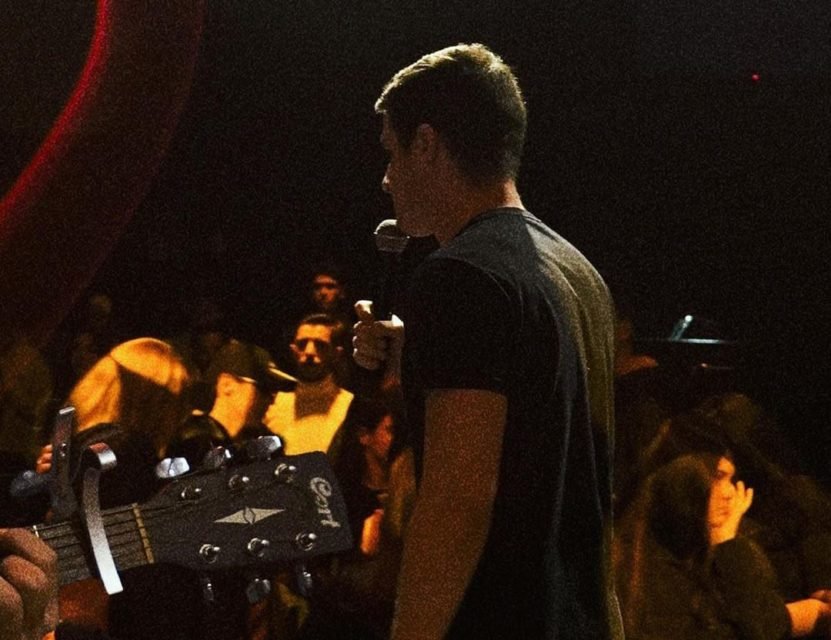 Foto colorida de culto no Galpão, com o influencer Victor Bonato, líder do movimento evangélico, pregando ao microfone - Metrópoles