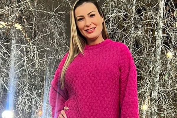 Andressa Urach posa de casaco rosa durante viagem - Metrópoles