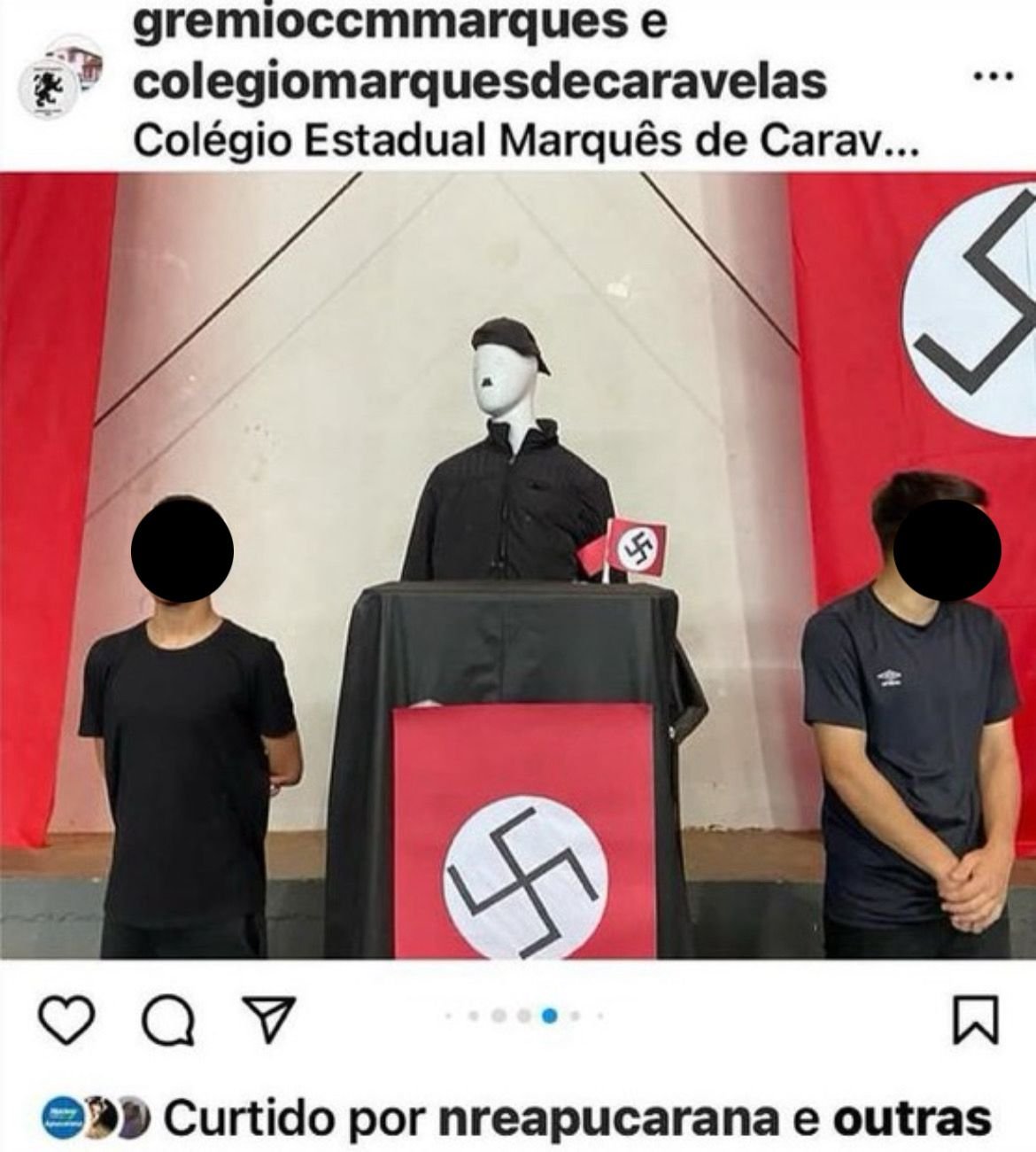 Imagem colorida de alunos perto de manequim que remete a Hitler com suásticas ao fundo - Metrópoles