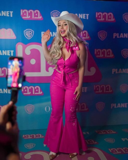 foto colorida de mulher loira vestida de conjunto rosa e chapeu branco de cauboi - metrópoles