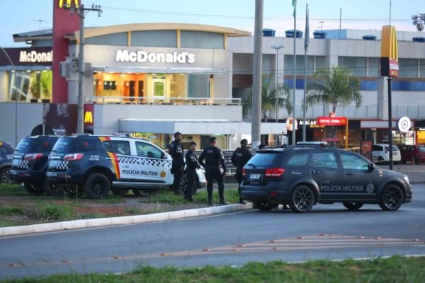 Carros da PMDF e policiais fardados em frente a posto de gasolina de Sobradinho; ao fundo, há uma loja do McDonald's, árvores e postes, em Sobradinho - Metrópoles