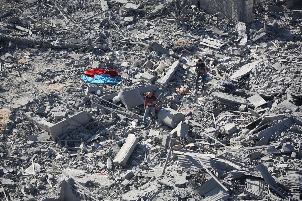 Cidadãos palestinos inspecionam danos às suas casas causados ​​por ataques aéreos israelenses em 13 de outubro de 2023 na Cidade de Gaza