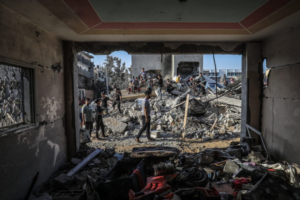 Palestinos inspecionam edifícios destruídos após ataques aéreos israelenses enquanto os combates entre tropas israelenses e militantes islâmicos do Hamas continuam
