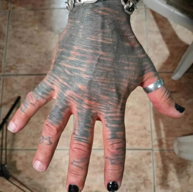 Mão de homem tatuada e com unhas pintadas de preto - Metrópoles