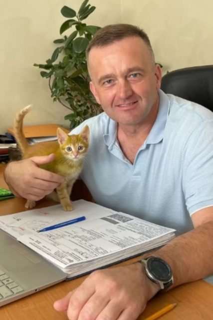 Foto colorida de um homem com um gato - Metrópoles