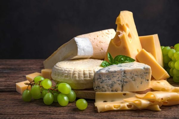 Foto mostra tábua de queijos, com queijo muçarela, parmesão e outors
