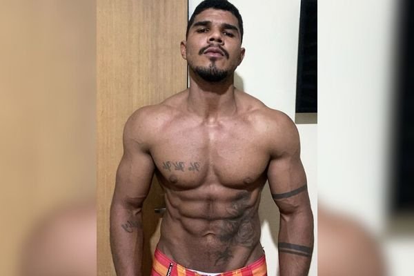 Imagem colorida mostra Eustácio Batista Dias, ex-campeão brasileiro de fisiculturismo; ele é um homem negro com o corpo definido, sem camisa, com uma bermuda vermelha - Metrópoles