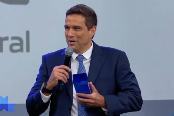 Imagem de Roberto Campos Neto, presidente do Banco Central, segurando um microfone e recebendo um prêmio - Metrópoles
