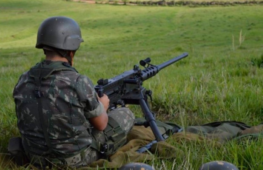 foto colorida de militar do Exército manuseando uma metralhadora ponto 50 - Metrópoles