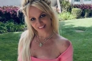 Britney Spears posa sorridente, de vestido rosa - Metrópoles