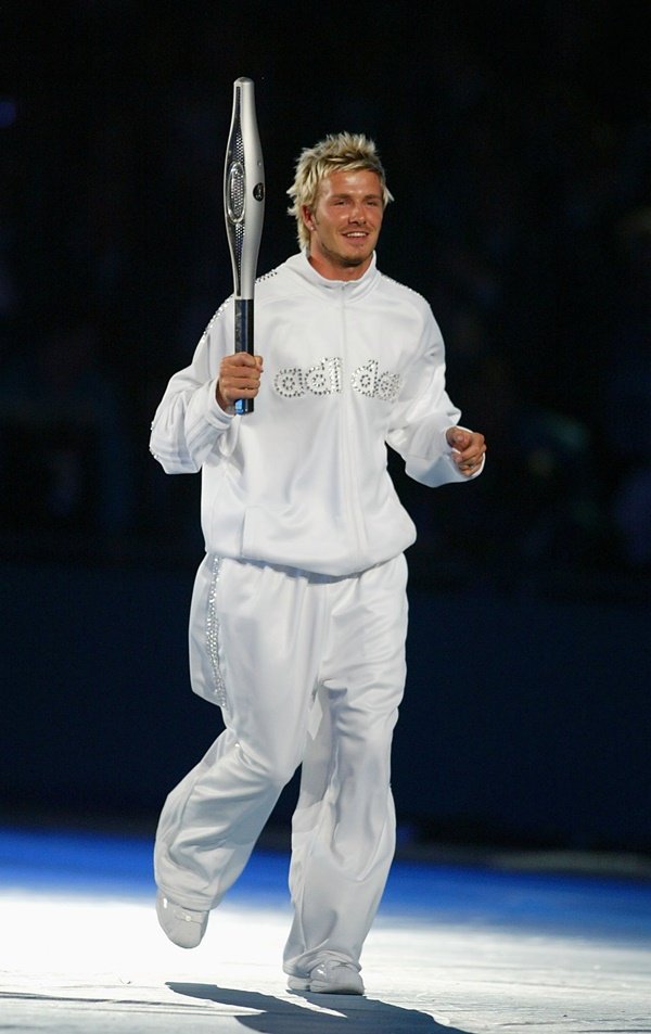 Foto em cores, David Beckham veste branco da Adidas e carrega raquete de tÊnis - Metrópoles