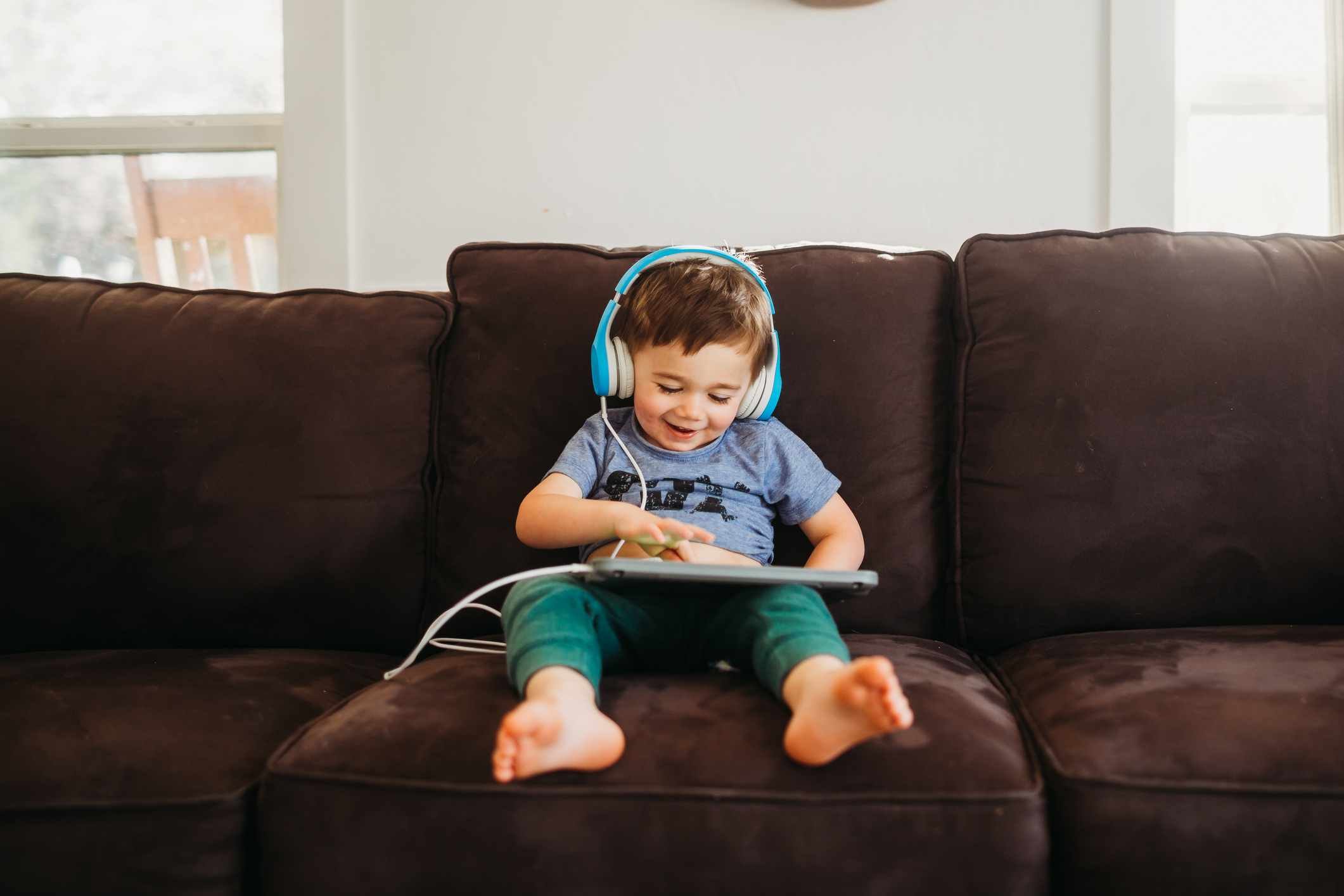 Foto mostra criança ouvindo música em um fone de ouvido colorido, barulho - Metrópoles
