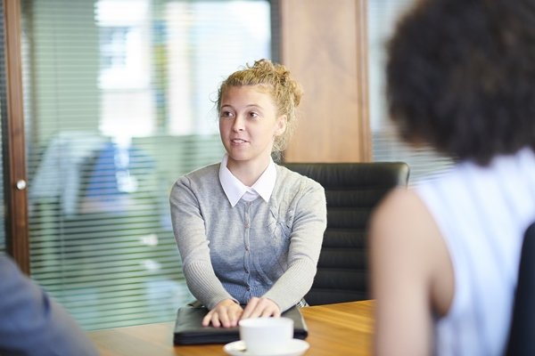 Jovem mulher sendo entrevistada para emprego - Metrópoles